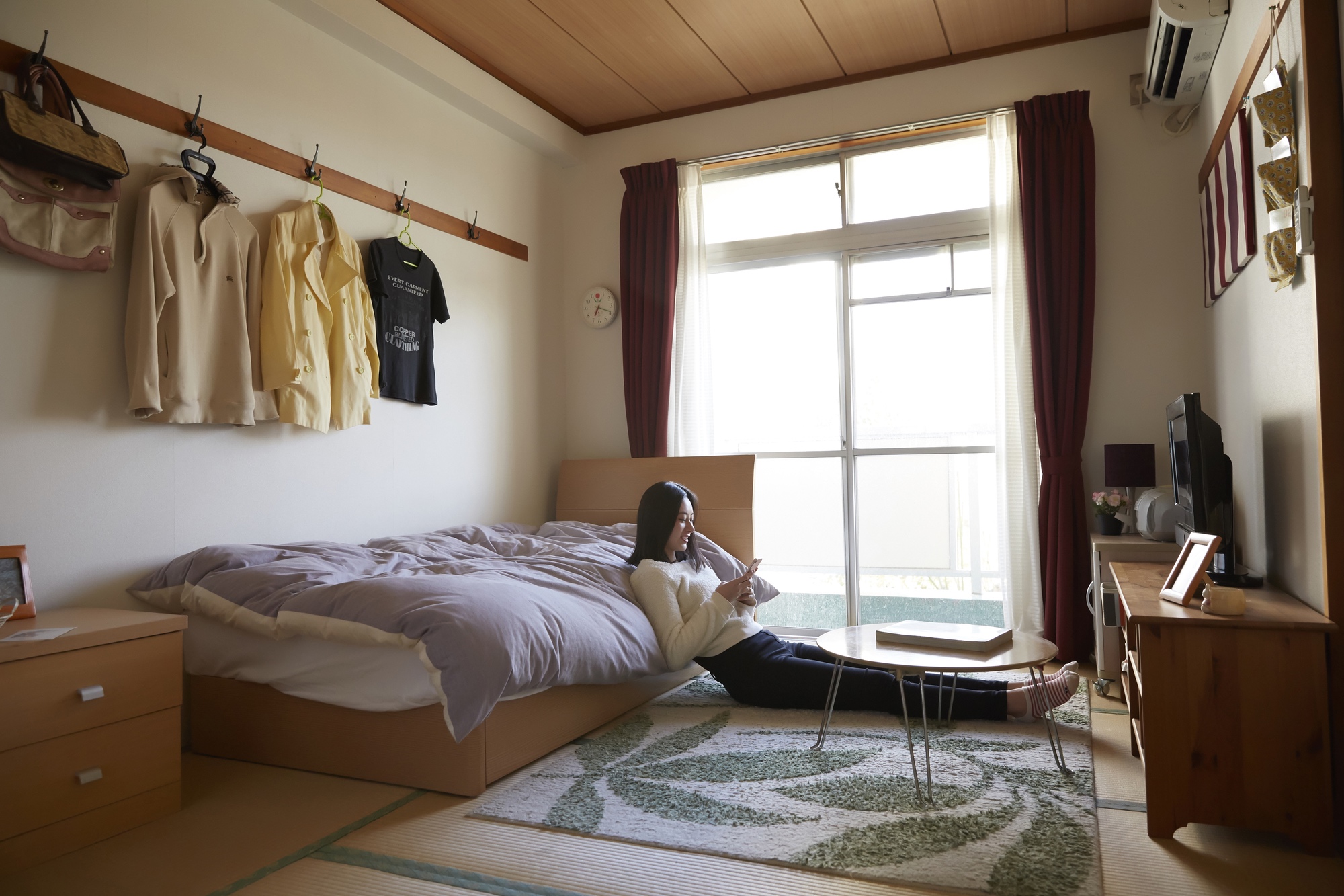 japanese woman laying on the floor propped up on her bed