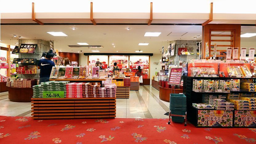 A Japanese gift store stocking savory and sweet snacks from different regions. People shopping